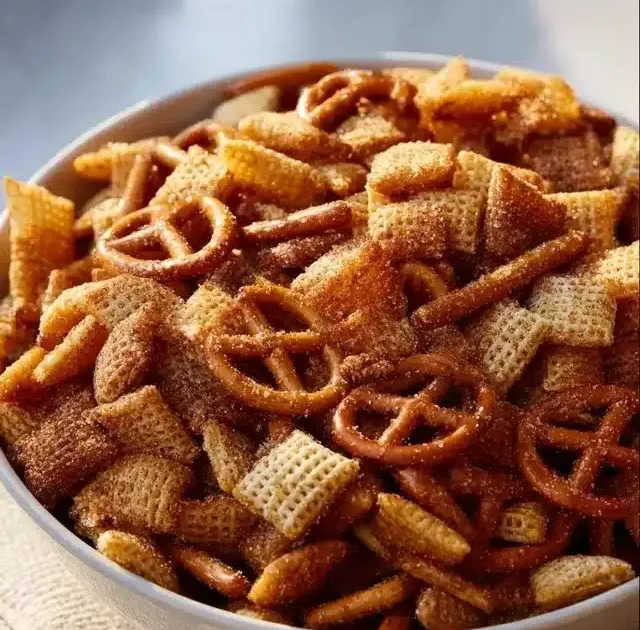 Delicious homemade Churro Chex Mix in a bowl with cinnamon and sugar.
