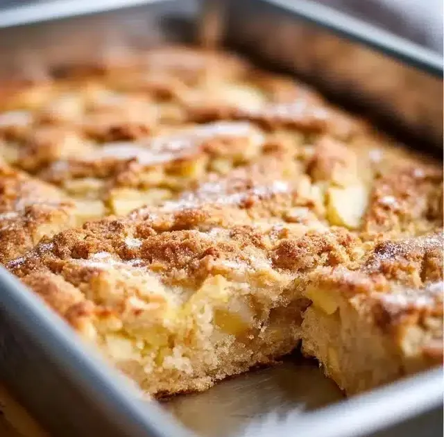 A slice of Parisian apple cake garnished with fresh apples and cinnamon.
