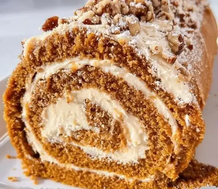 Pumpkin roll dessert with caramel praline frosting on a rustic table