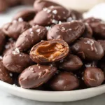 Delicious chocolate covered almonds in a bowl, perfect for snacking.