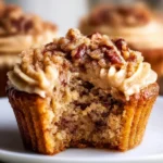 Pecan Pie Cupcakes topped with brown sugar frosting on a wooden table
