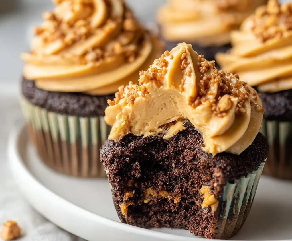 Dark chocolate cupcakes with creamy peanut butter frosting on a decorative plate