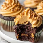 Dark chocolate cupcakes with creamy peanut butter frosting on a decorative plate