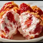 A colorful bowl of strawberry fluff salad with whipped cream and marshmallows