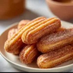 Healthy baked churro bites served on a plate, dusted with cinnamon sugar.