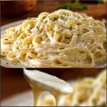 Bowl of homemade Alfredo sauce served over fettuccine pasta.