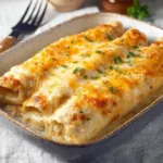 Delicious white chicken enchiladas topped with creamy sauce and garnished.