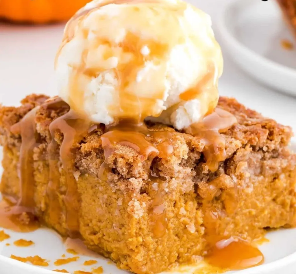Delicious pumpkin spice dump cake topped with whipped cream.