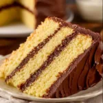 Yellow birthday cake with chocolate frosting, ideal for celebrations.