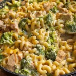 Cheesy Chicken Broccoli Mac garnished with broccoli and chicken pieces