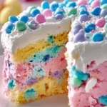 Colorful Easter Poke Cake topped with whipped cream and pastel decorations