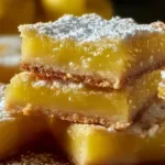 Delicious homemade lemon bars with a dusting of powdered sugar on a white plate
