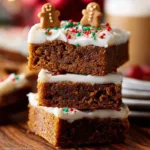 Gingerbread cookie bars with spiced cream cheese frosting on a plate