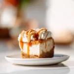 Pumpkin cheesecake with gingersnap crust topped with whipped cream and autumn spices.