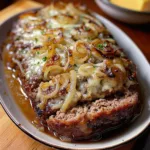 Delicious Crockpot French Onion Beefloaf served with melted cheese and caramelized onions.