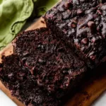 Slice of double chocolate zucchini bread with chocolate chips on top
