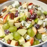Fruit salad topped with sour cream dressing, showcasing colorful mixed fruits.