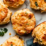 Freshly baked homemade cheddar biscuits served on a plate