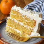 Mandarin Orange Cake topped with creamy pineapple frosting on a decorative plate